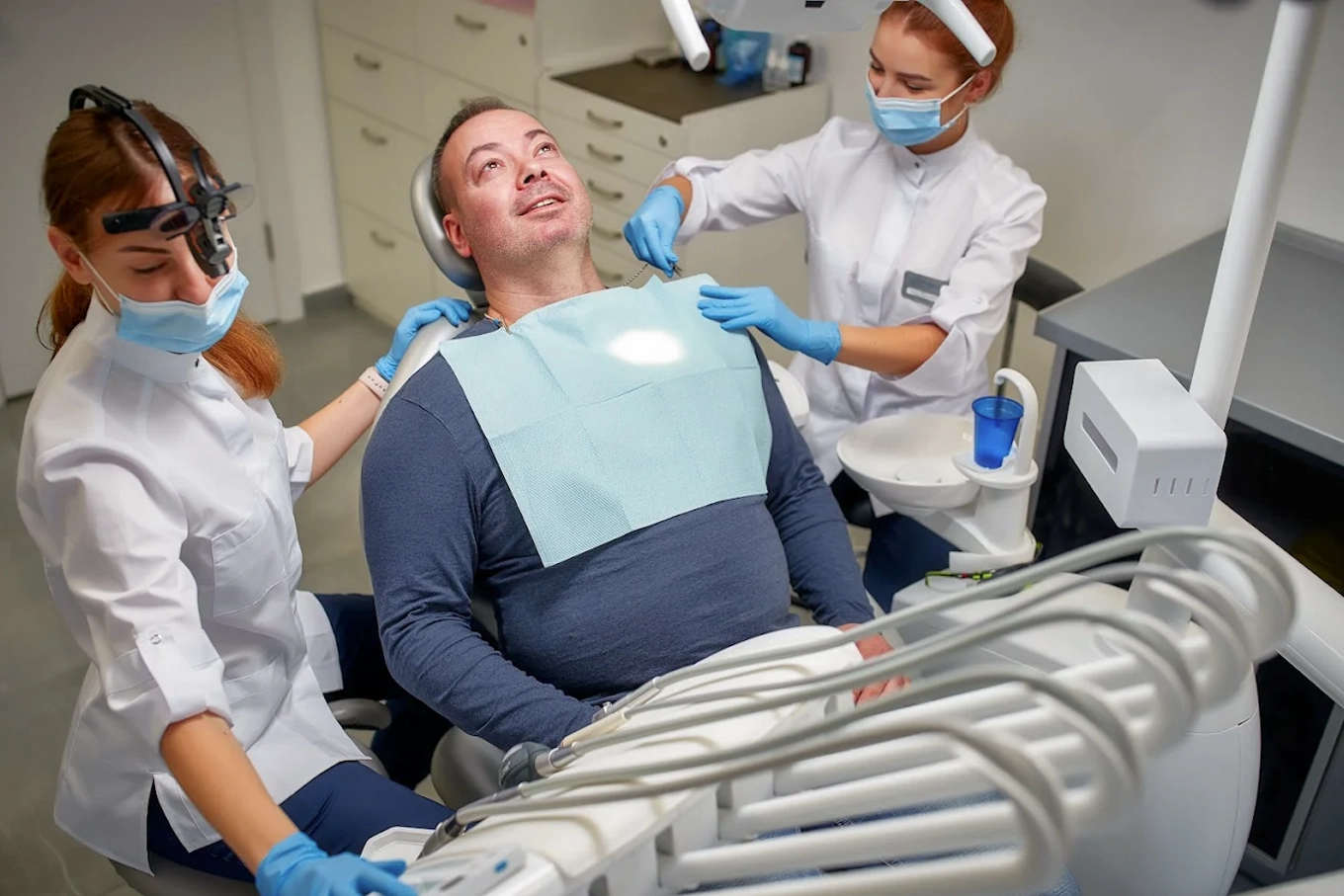 Дві лікарки DRT Clinic готують пацієнта до стоматологічного лікування